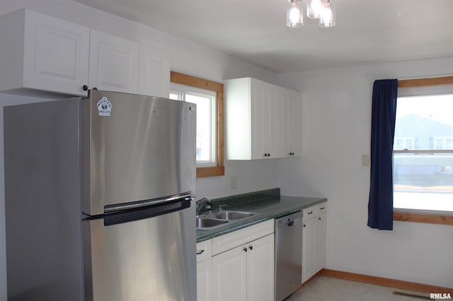 kitchen featuring stainless steel appliances, a healthy amount of sunlight, sink, and white cabinets