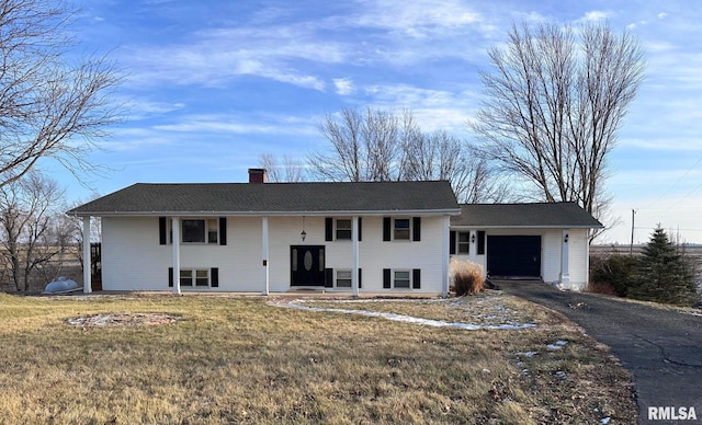 bi-level home with a garage and a front lawn