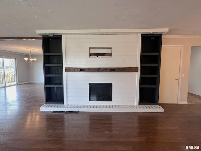 unfurnished living room featuring ornamental molding, dark wood-type flooring, a notable chandelier, and a fireplace