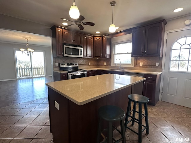 kitchen with light tile patterned flooring, sink, stainless steel appliances, crown molding, and dark brown cabinets