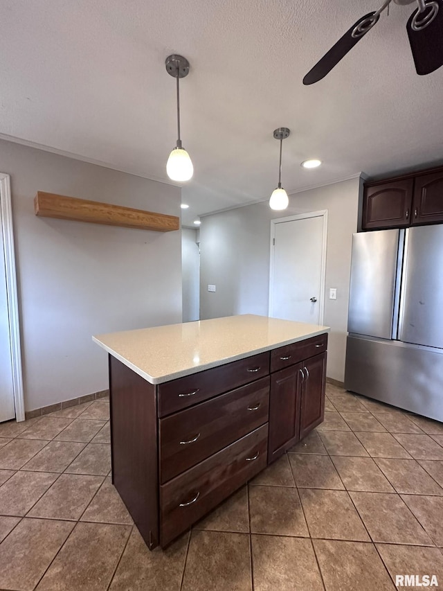 kitchen with stainless steel fridge, decorative light fixtures, dark brown cabinets, and light tile patterned floors