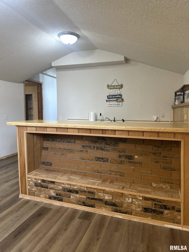 details featuring hardwood / wood-style flooring, a textured ceiling, and bar area