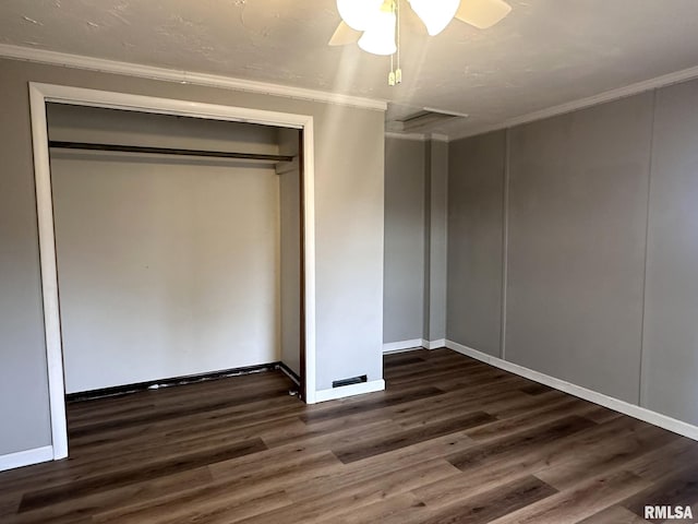 unfurnished bedroom featuring ceiling fan, ornamental molding, dark hardwood / wood-style flooring, and a closet