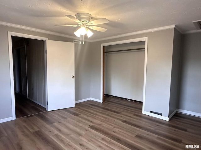 unfurnished bedroom with crown molding, ceiling fan, dark hardwood / wood-style floors, and a closet