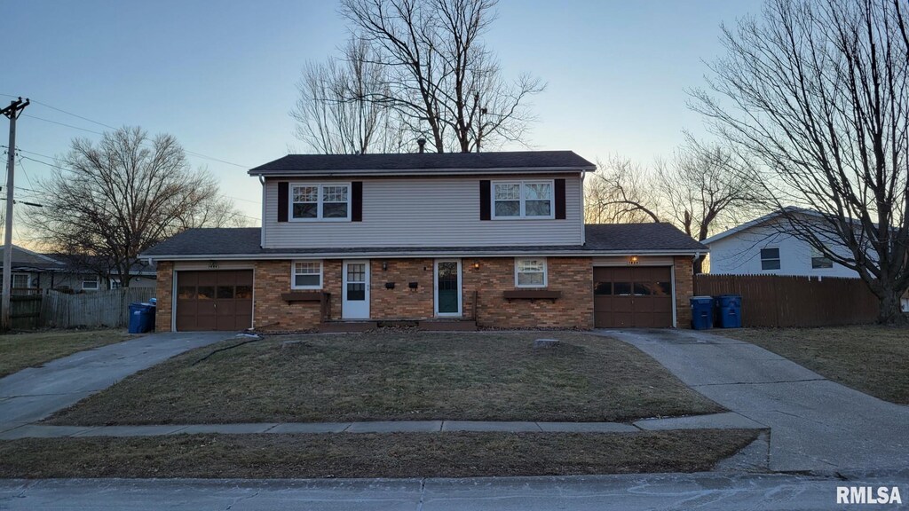 view of front of home with a garage and a lawn