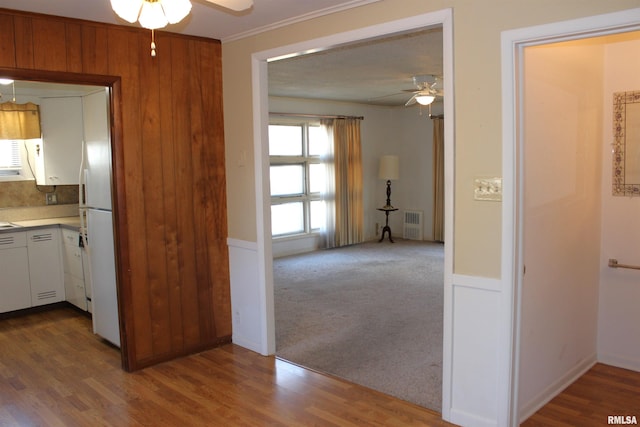 hallway with ornamental molding and carpet floors