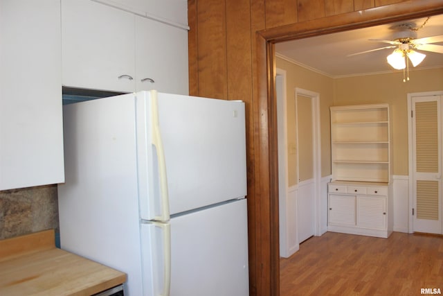 kitchen with white refrigerator, ceiling fan, crown molding, and light wood-type flooring