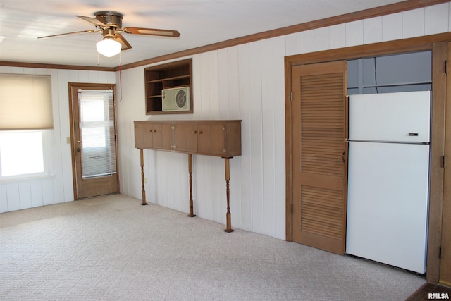 kitchen featuring ceiling fan, light colored carpet, ornamental molding, and white fridge