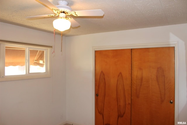 unfurnished bedroom featuring ceiling fan, a closet, and a textured ceiling