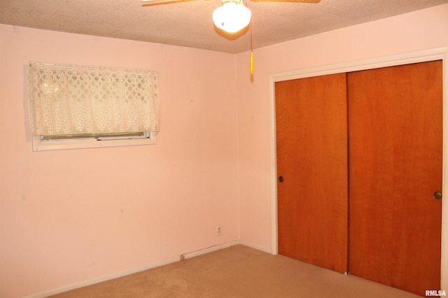 unfurnished bedroom featuring carpet, a textured ceiling, ceiling fan, and a closet