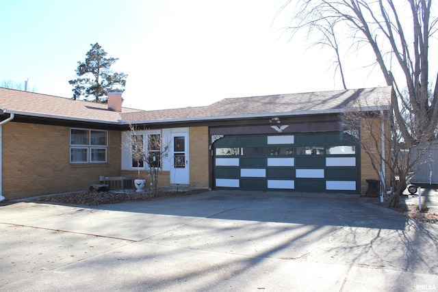 single story home with a garage and central air condition unit