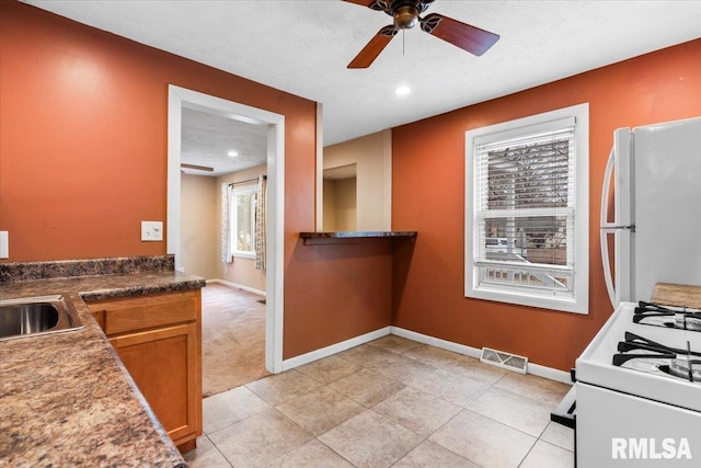 kitchen with ceiling fan, sink, a textured ceiling, and white appliances