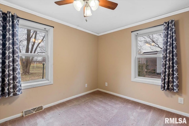 carpeted empty room featuring a wealth of natural light, ornamental molding, and ceiling fan