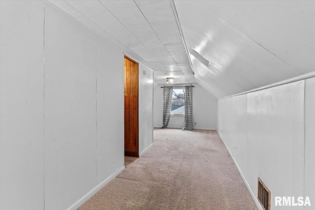 hall with light colored carpet and vaulted ceiling