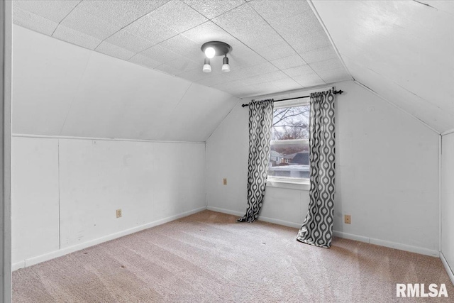 additional living space featuring vaulted ceiling and carpet floors