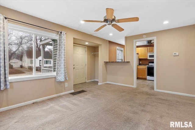 empty room featuring light carpet and ceiling fan