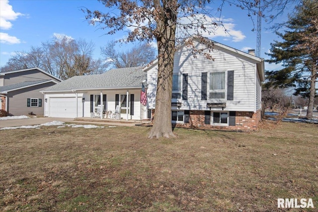 split level home featuring a garage, a front lawn, and covered porch