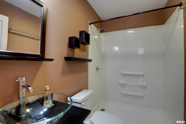 bathroom with sink, toilet, and walk in shower