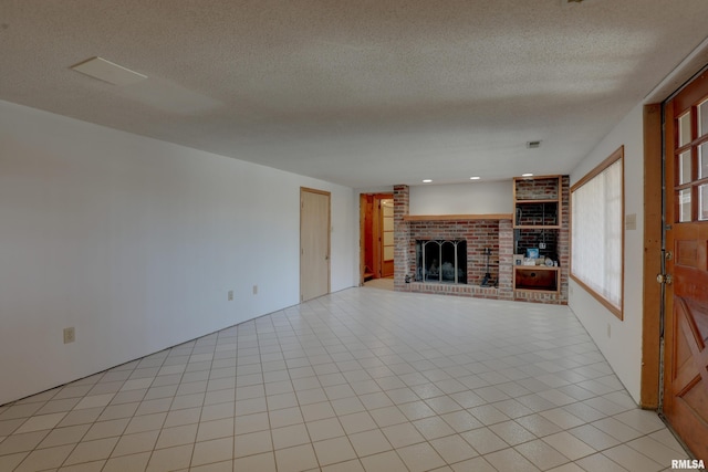 unfurnished living room with a fireplace, a textured ceiling, and light tile patterned floors