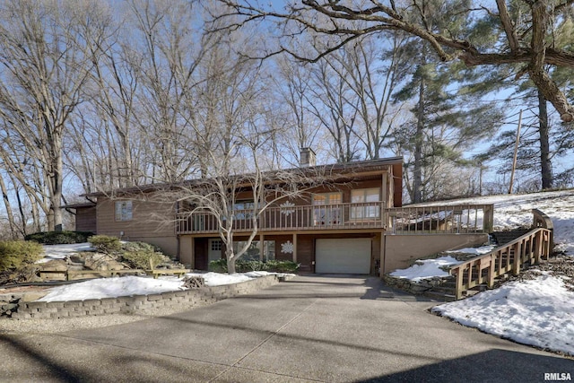 view of front facade featuring a wooden deck and a garage