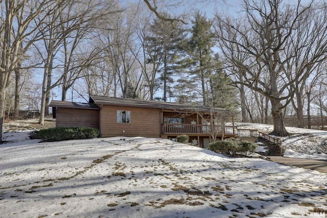 snow covered house featuring a wooden deck