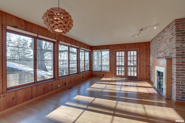 unfurnished sunroom featuring a fireplace and rail lighting