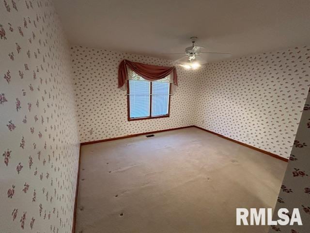 carpeted spare room featuring ceiling fan