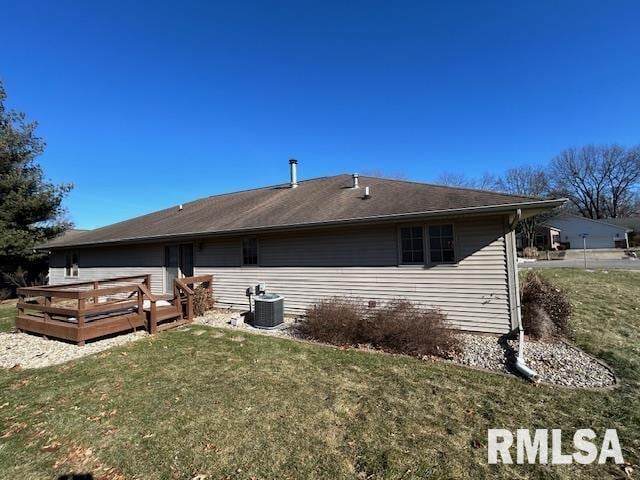 rear view of house with a wooden deck, a yard, and central AC