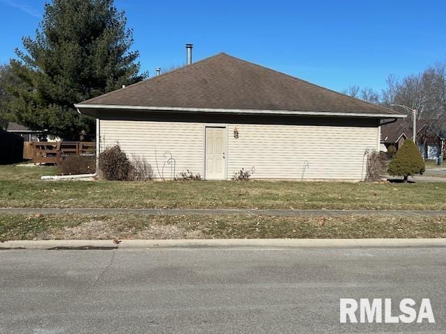 view of side of home with a yard