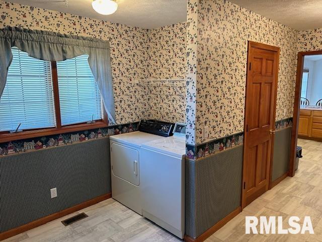 washroom featuring washer and dryer and a textured ceiling