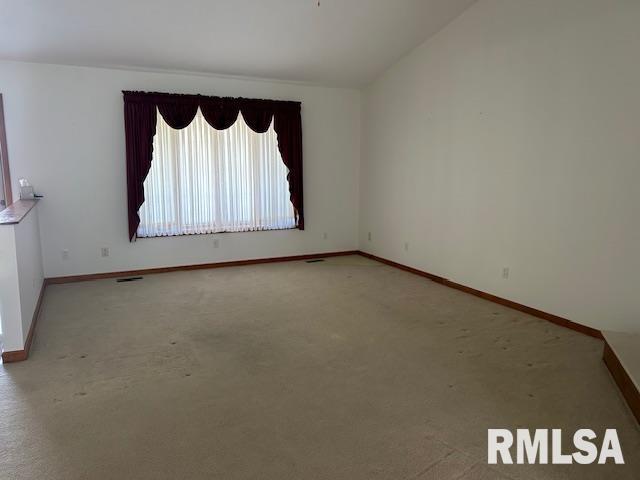 spare room featuring lofted ceiling and carpet