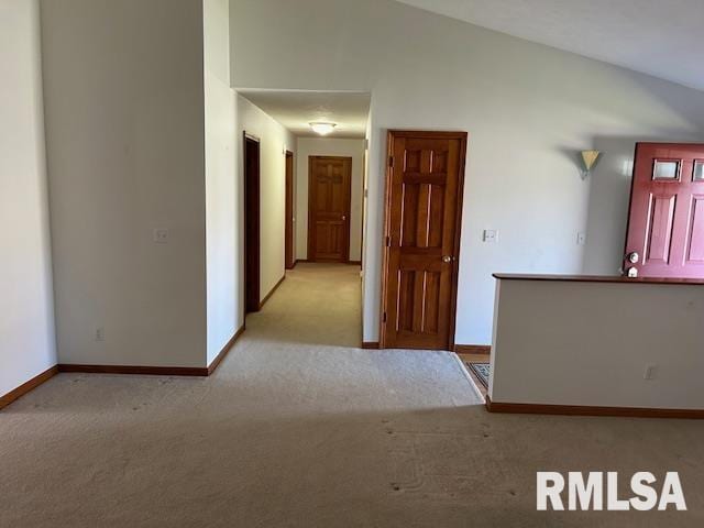 unfurnished room featuring light colored carpet and lofted ceiling