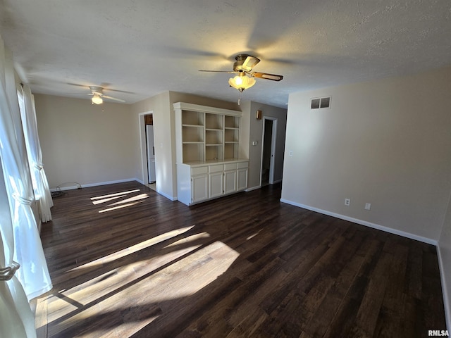 spare room with ceiling fan, dark wood-type flooring, and a textured ceiling