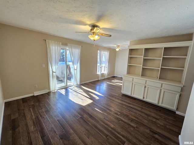 unfurnished living room featuring dark hardwood / wood-style flooring, ceiling fan, and a textured ceiling