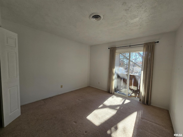 carpeted empty room featuring a textured ceiling