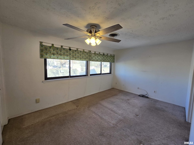 empty room featuring ceiling fan, carpet floors, and a textured ceiling