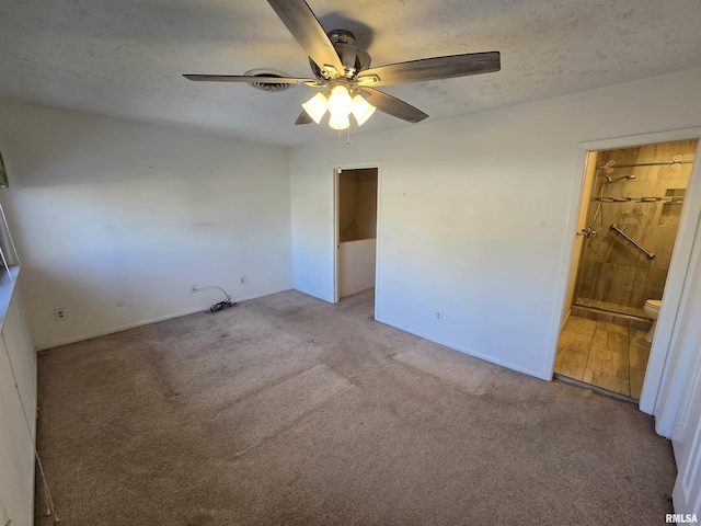 spare room with ceiling fan, light carpet, and a textured ceiling