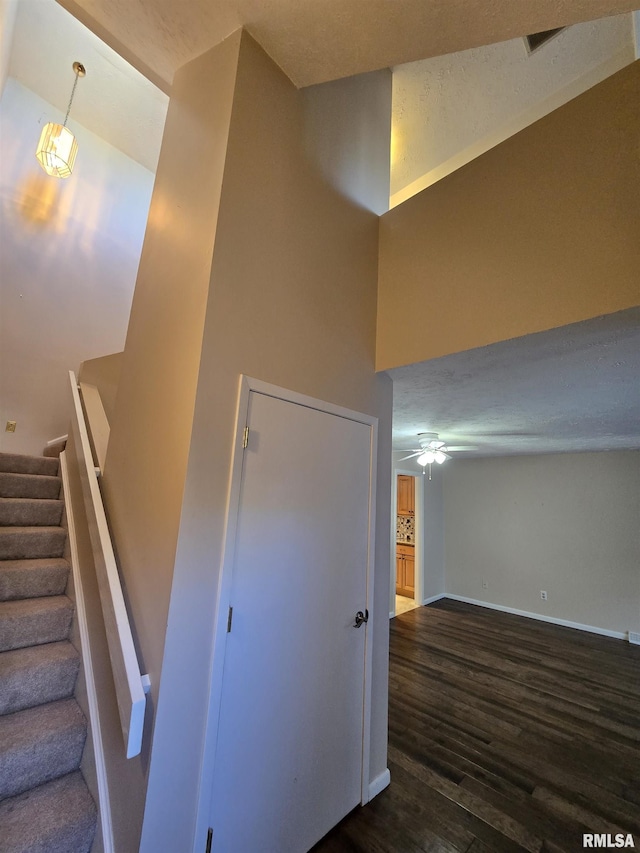 staircase with hardwood / wood-style floors and ceiling fan