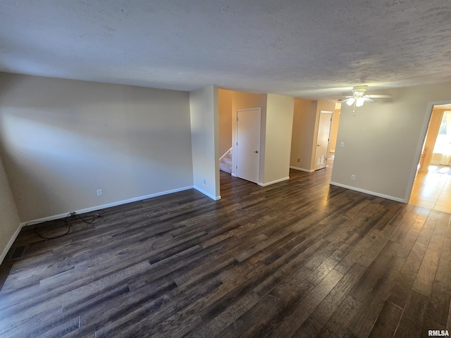 empty room featuring ceiling fan, dark wood-type flooring, and a textured ceiling