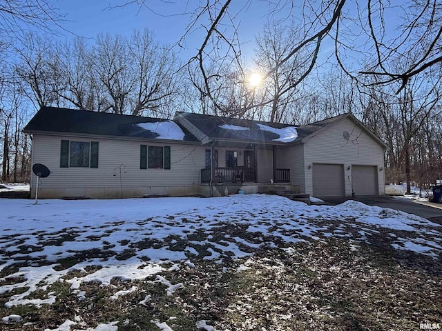 single story home featuring driveway, a porch, and an attached garage