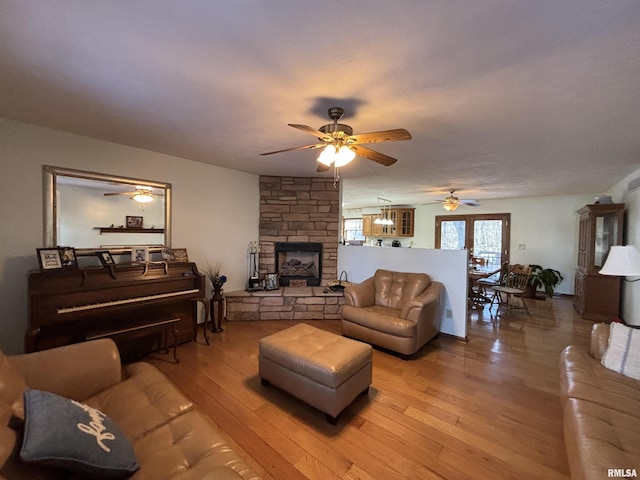 living room with hardwood / wood-style floors, a fireplace, and ceiling fan