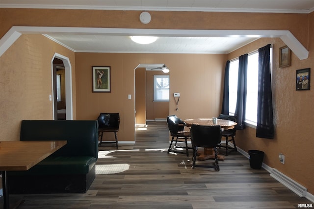 dining area with crown molding and dark wood-type flooring