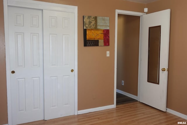 unfurnished bedroom featuring a closet and light hardwood / wood-style flooring