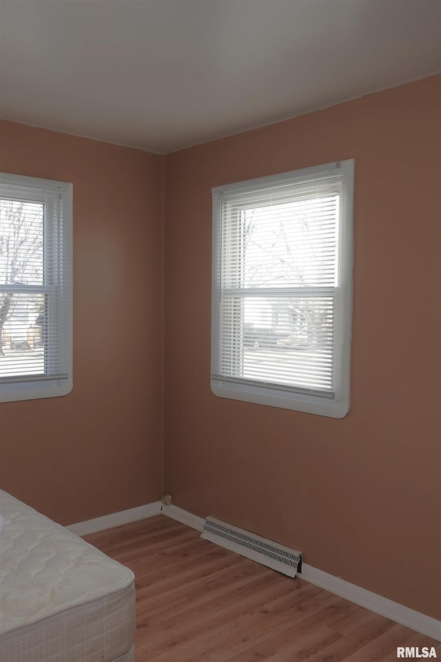 unfurnished bedroom featuring multiple windows and wood-type flooring