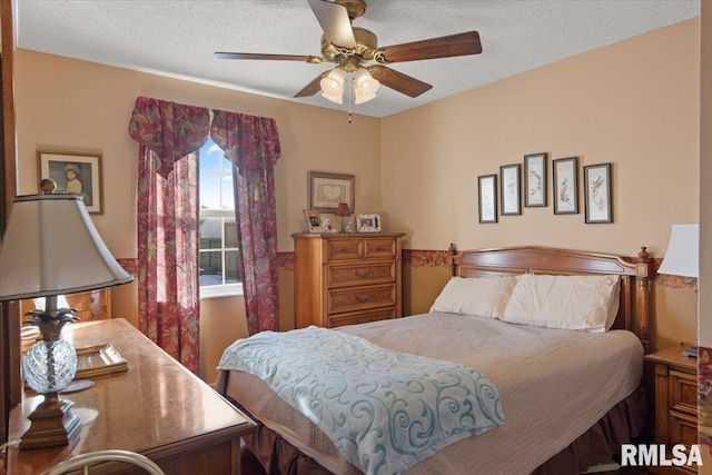 bedroom with ceiling fan and a textured ceiling