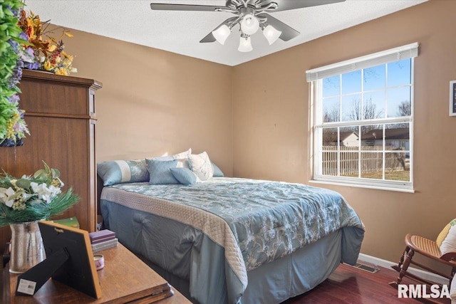 bedroom with hardwood / wood-style floors, a textured ceiling, and ceiling fan