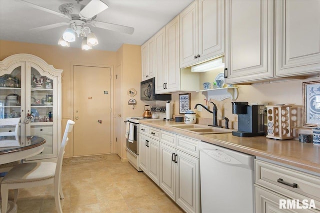 kitchen featuring ceiling fan, sink, white cabinets, and white appliances