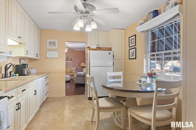 kitchen featuring white refrigerator, ceiling fan, and sink