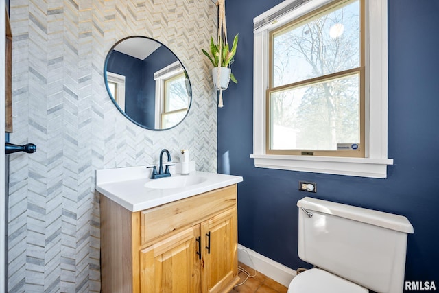 bathroom featuring backsplash, vanity, toilet, and a wealth of natural light