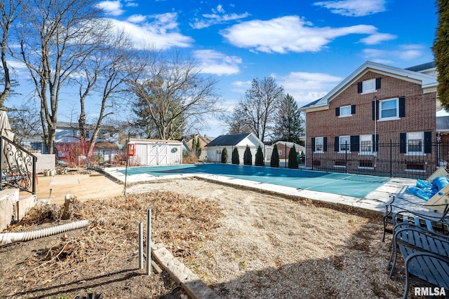 view of pool with a patio area and a shed